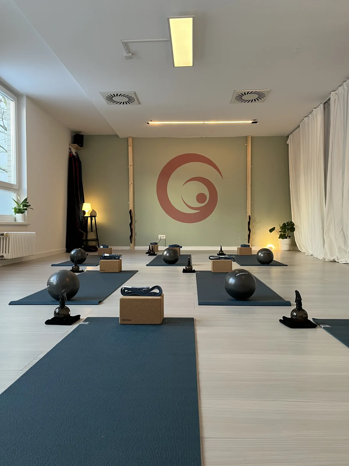 Mattenraum mit Pilatesb&auml;llen und der Lyra-Spirale an der Wand