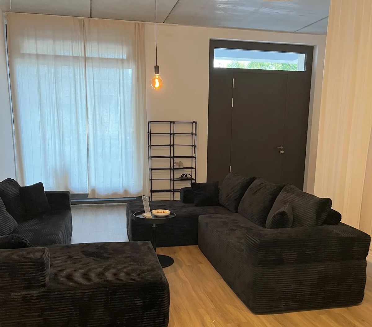 Reception area with soft dark sofas beside the studio entrance